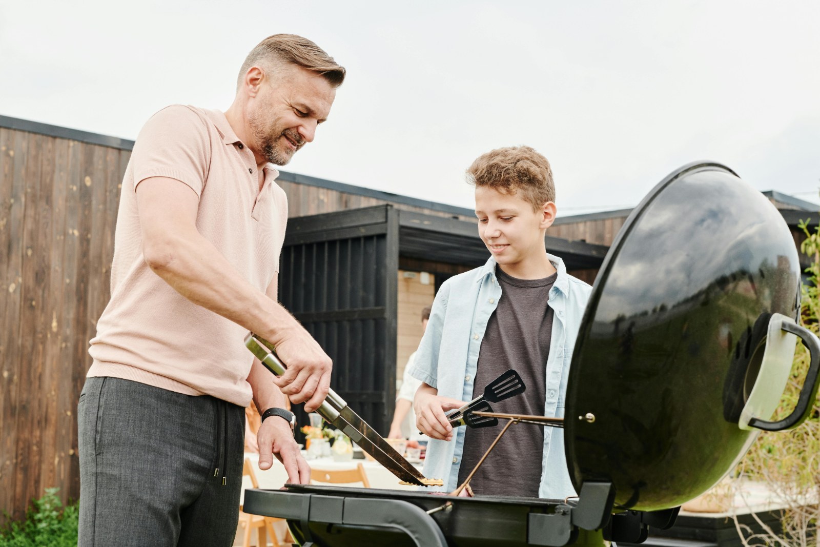father and son grilling on the backyard