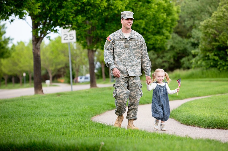 American soldier walking with his daughter