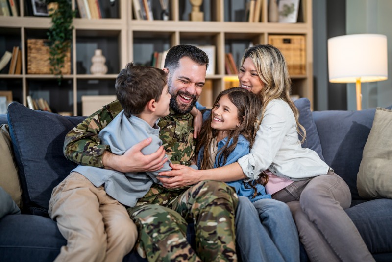 Father hugging family after military homecoming