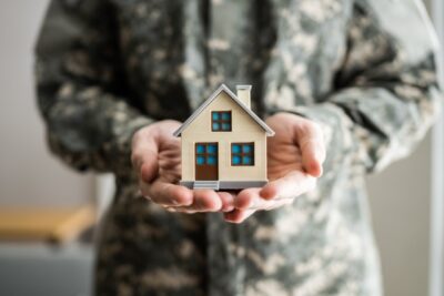 Military man holding a model home